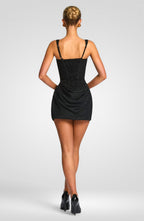 Woman wearing a black dress on a plain background