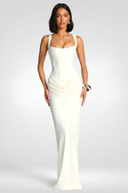 Woman wearing a white evening gown on a plain background