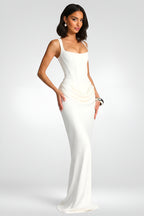 Woman wearing a white evening gown against a gray background