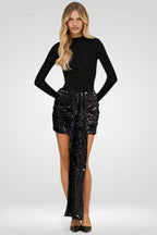 Woman wearing a black long-sleeve top and black sequin skirt on a white background