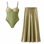 Green lace bodysuit and satin skirt on a white background