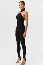 Woman wearing a black halter neck jumpsuit on a white background