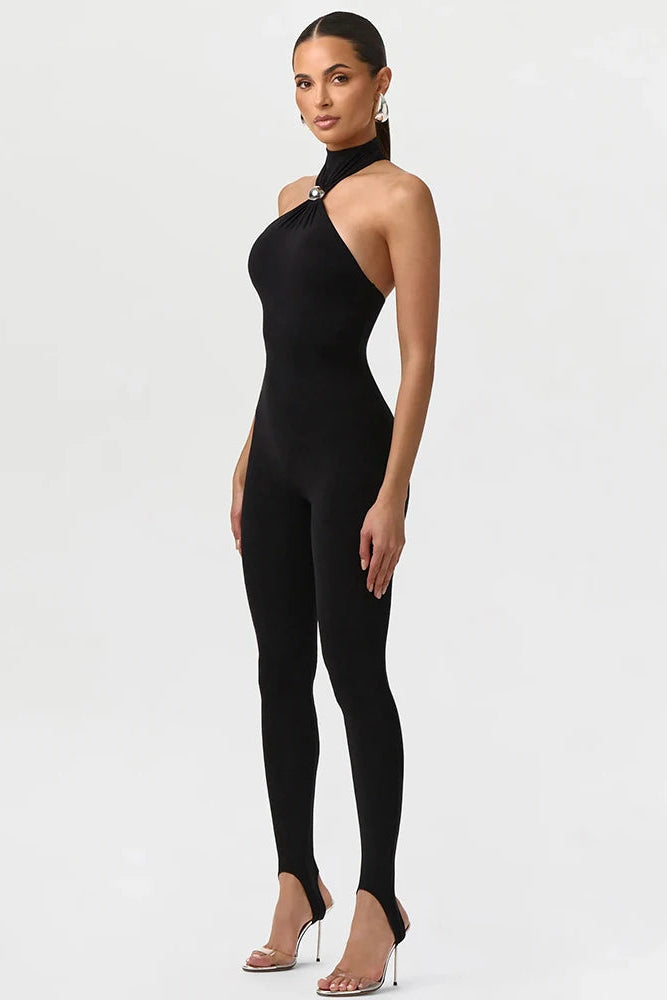 Woman wearing a black halter neck jumpsuit on a white background