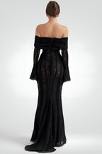 Black off-shoulder evening gown with intricate detailing on a white background