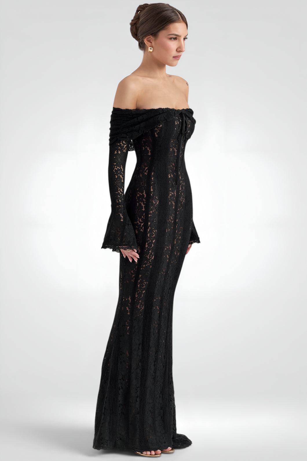 Woman wearing a black off-shoulder gown with long sleeves on a white background