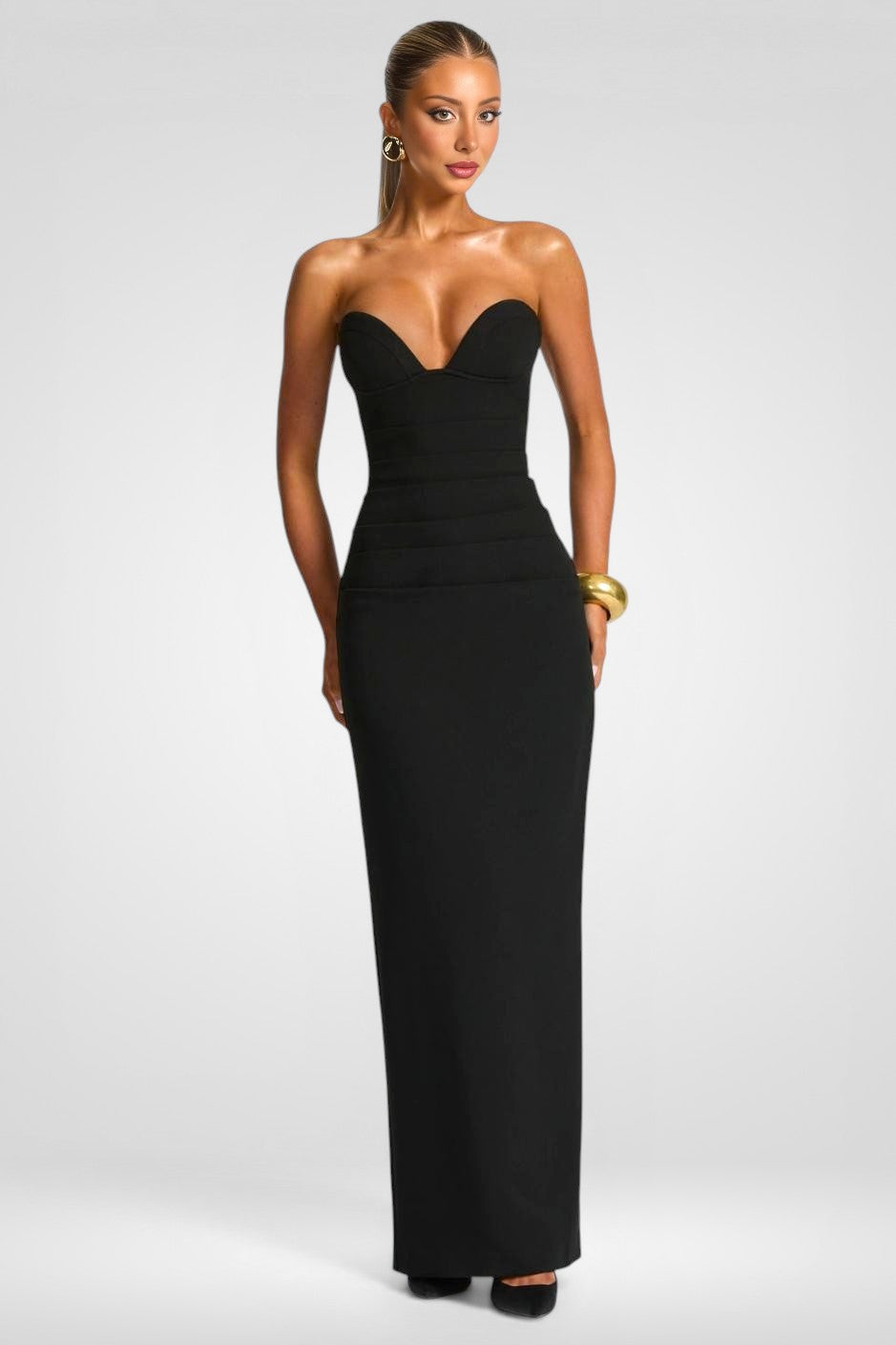 Woman wearing a black strapless gown on a white background