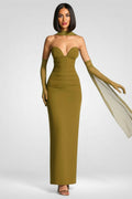 Woman wearing a green strapless gown with a white scarf on a gray background