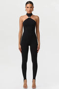 Woman wearing a black halter neck jumpsuit on a white background