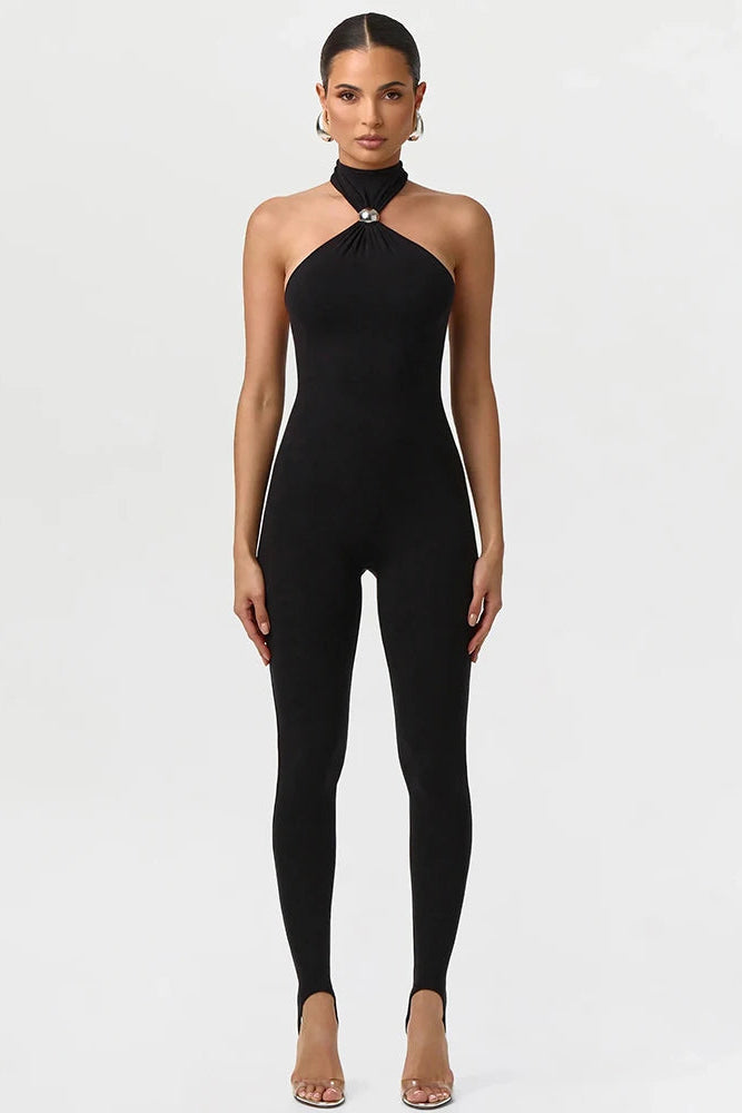 Woman wearing a black halter neck jumpsuit on a white background
