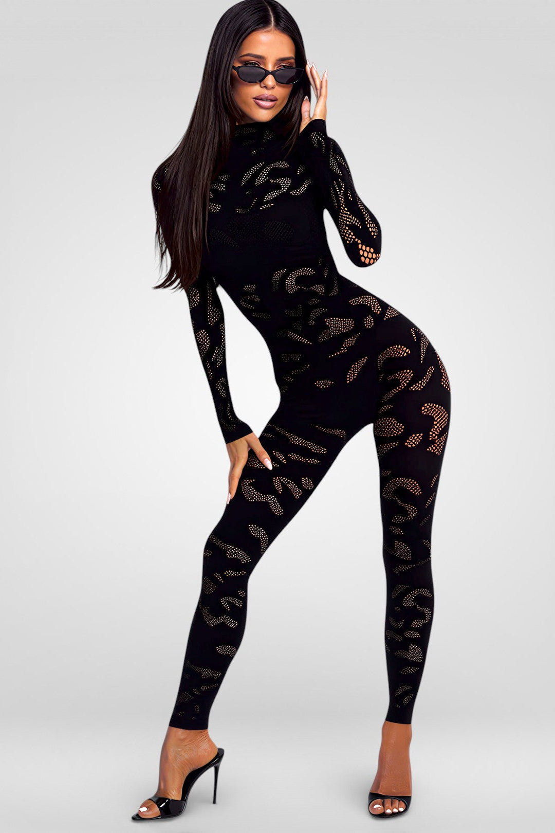Woman wearing a black jumpsuit with question mark pattern on a white background