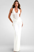 Woman wearing a white halter neck gown on a gray background