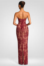 Woman wearing a strapless, lace-up burgundy evening gown on a white background