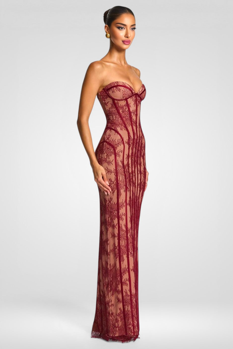 Woman wearing a burgundy lace strapless gown on a white background