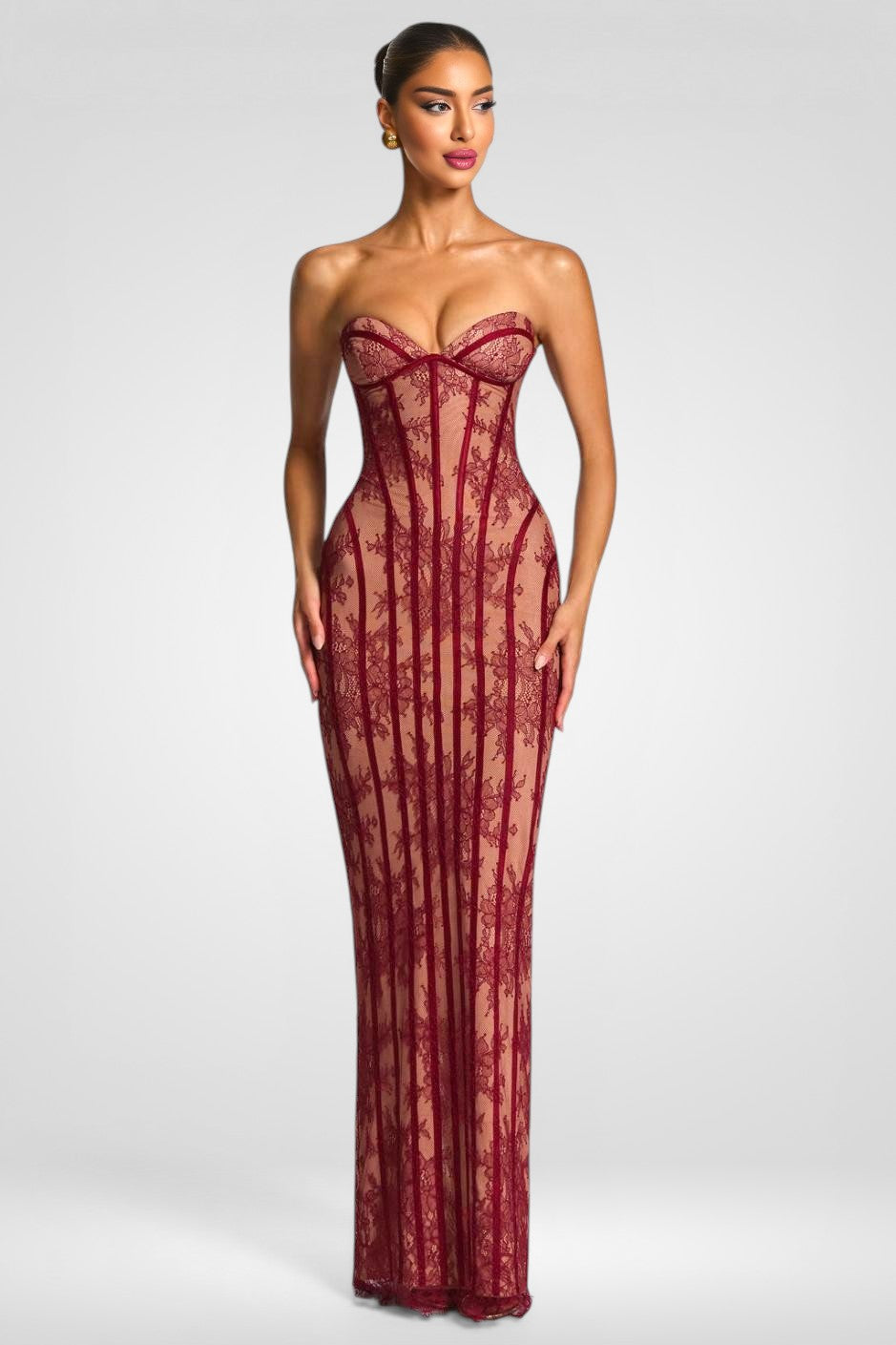 Woman wearing a red lace strapless gown on a white background