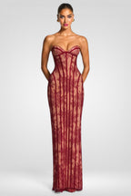 Woman wearing a strapless red lace evening gown on a white background