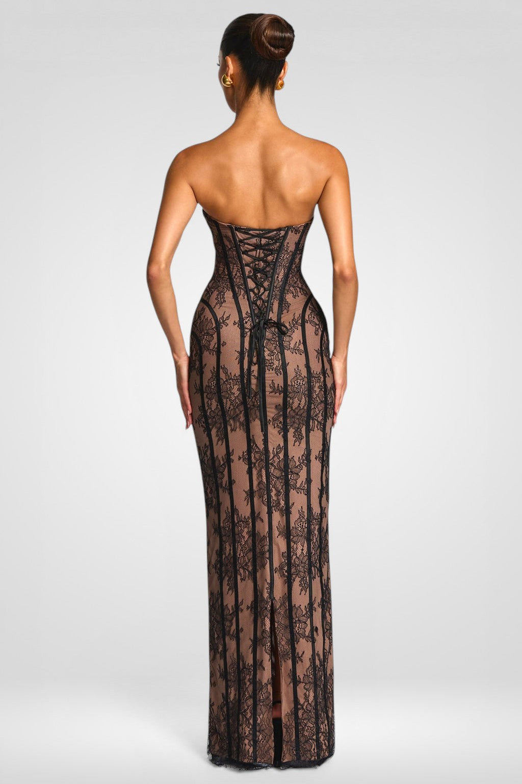 Woman wearing a black lace strapless gown on a white background