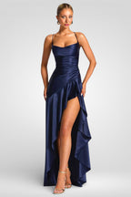 Woman wearing a navy blue evening gown with a high slit on a white background