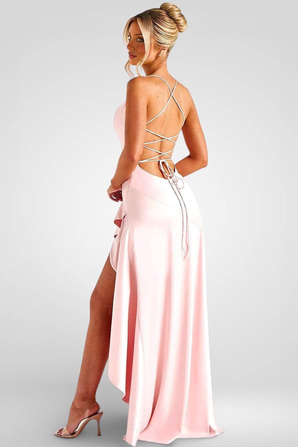 Woman wearing a pink evening gown with a strappy back design on a white background