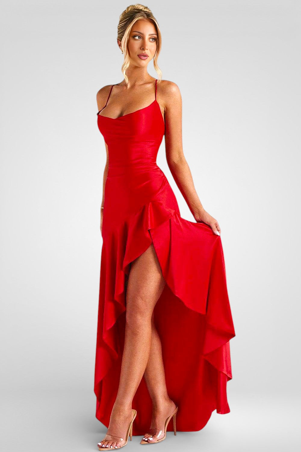 Woman wearing a red dress with a high slit on a gray background