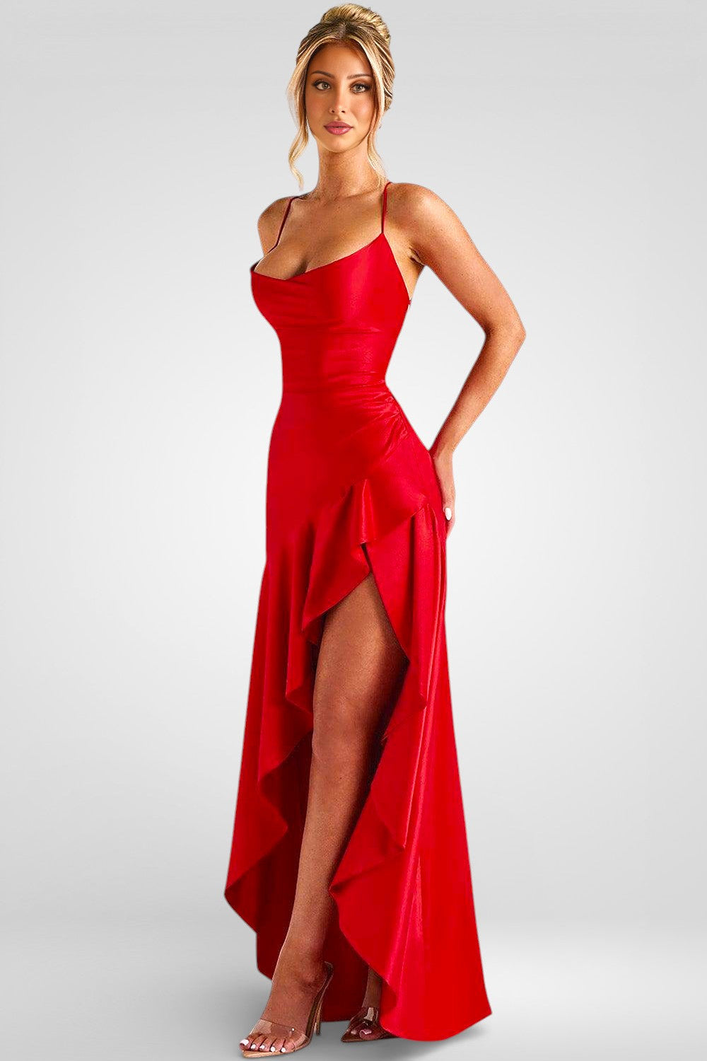 Woman wearing a red evening gown with a high slit on a gray background