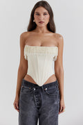 Woman wearing a strapless top and jeans on a white background