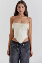 Woman wearing a strapless top and jeans on a white background