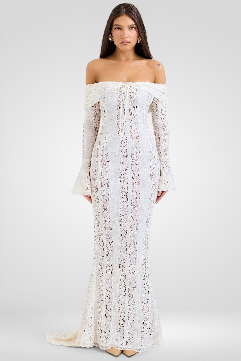 Woman wearing a white lace dress on a plain background
