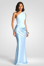 Woman wearing a light blue one-shoulder gown on a white background