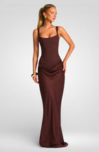 Woman wearing a brown evening gown on a plain background