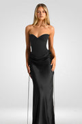 Woman wearing a black strapless gown on a white background