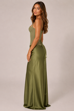 Woman wearing an olive green evening gown with a plain background