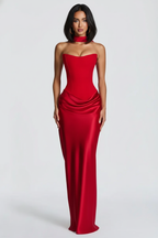 Woman wearing a strapless red evening gown on a white background