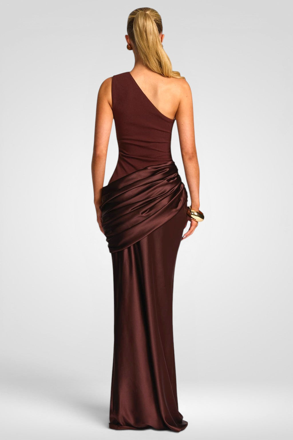 Woman wearing a brown one-shoulder evening gown on a white background