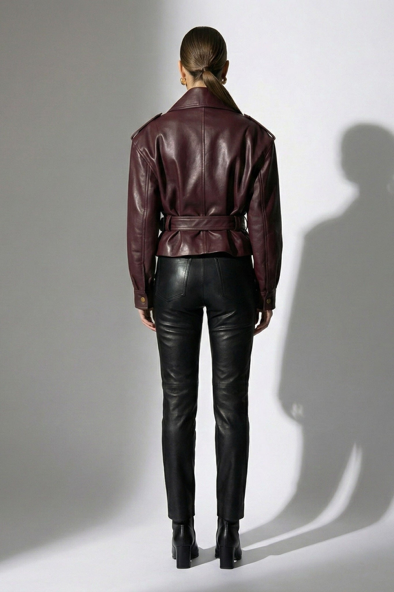 Burgunderfarbene PU-Lederjacke mit Schnallen, taillierter Passform und Reißverschlussdetails 